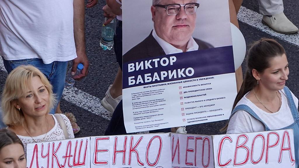 ARCHIV - Menschen tragen bei einer Demonstration gegen Machthaber Lukschenko ein Transparent mit dem Foto von Viktor Babariko. Foto: Ulf Mauder/dpa