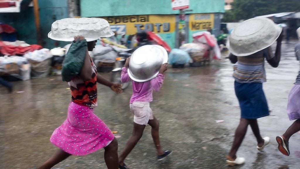 Nichts wie weg - Bewohner der haitianischen Hauptstadt Port-au-Prince fliehen vor den Fluten.