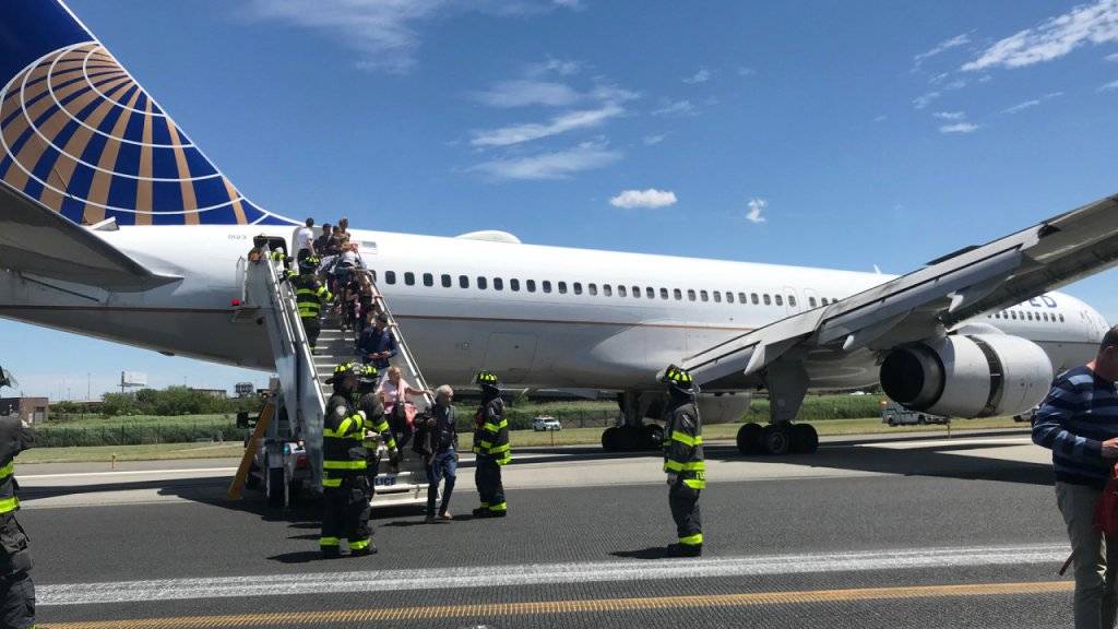 Rettungspersonal hilft bei der Evakuierung eines Flugzeugs der United Airlines, das auf dem Flughafen Newark bei New York teilweise von der Landebahn abgekommen ist.  (Caroline Craddock via AP)
