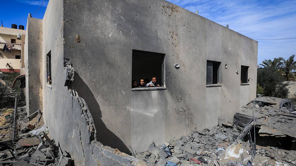 Palästinenser schauen aus einem Fenster, nachdem ein israelischer Luftangriff das Haus der Familie Al-Shaer östlich von Rafah zerstört hat. Foto: Mohammed Talatene/dpa