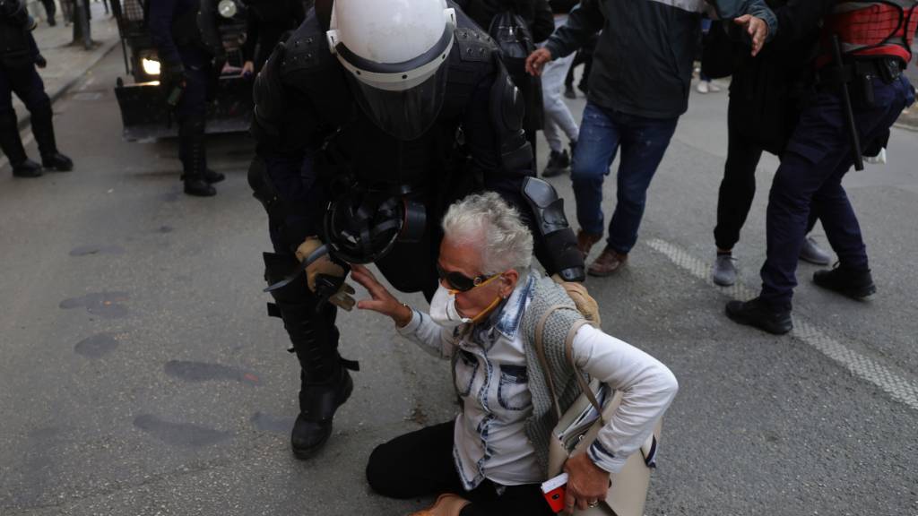 Ein Beamter der Bereitschaftspolizei versucht, einen Demonstranten während einer regierungskritischen Demonstration von der Straße zu bringen. Foto: Hameraldi Agolli/AP/dpa