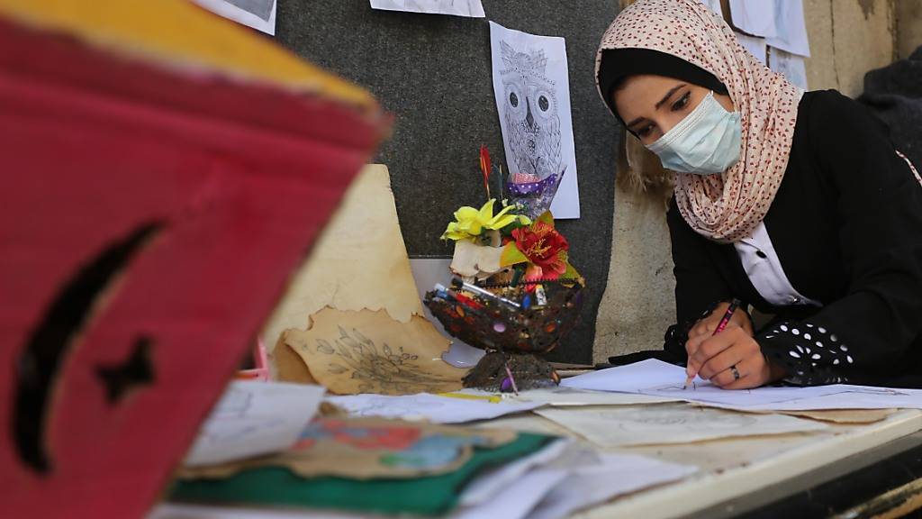 Die palästinensische Künstlerin Asma al-Aqra'a zeichnet Wahlurnen auf Papier in ihrem Haus vor den palästinensischen Parlamentswahlen. Foto: Ashraf Amra/APA Images via ZUMA Wire/dpa