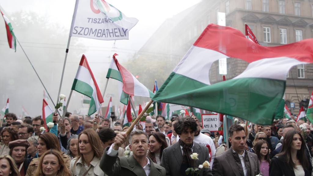 Peter Magyar (vorne M), Vorsitzender der ungarischen Oppositionspartei TISZA, nimmt an einer Demonstration zum 69. Jahrestag des Ausbruchs der ungarischen Revolution von 1956 gegen die kommunistische Herrschaft und die Sowjetunion in der ungarischen Hauptstadt teil. Foto: Rudolf Karancsi/AP/dpa
