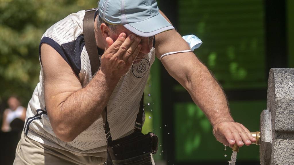 Ein Mann versucht, sich in einem Brunnen im Retiro-Park in Madrid abzukühlen. Foto: Andrea Comas/AP/dpa
