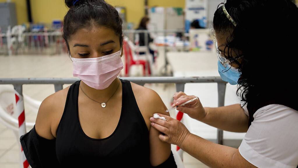 Ein Mitarbeiter der Gesundheitsbehörde in Guatemala gibt einer Frau einen Covid-Booster mit dem Impfstoff AstraZeneca. In vielen Ländern nehmen die Corona-Infektionen wieder rapide zu. Eine internationale Allianz fordert die Freigabe von Covid-19-Impfstoffpatenten für ärmere Länder.