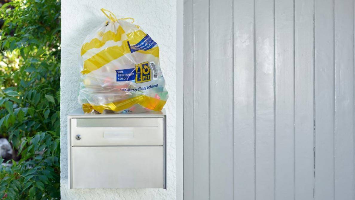 Die Rückgabe der leeren PET-Flaschen erfolgt über 45-Liter-Sammelsäcke, die sichtbar bei den Briefkästen am Hauseingang platziert werden.