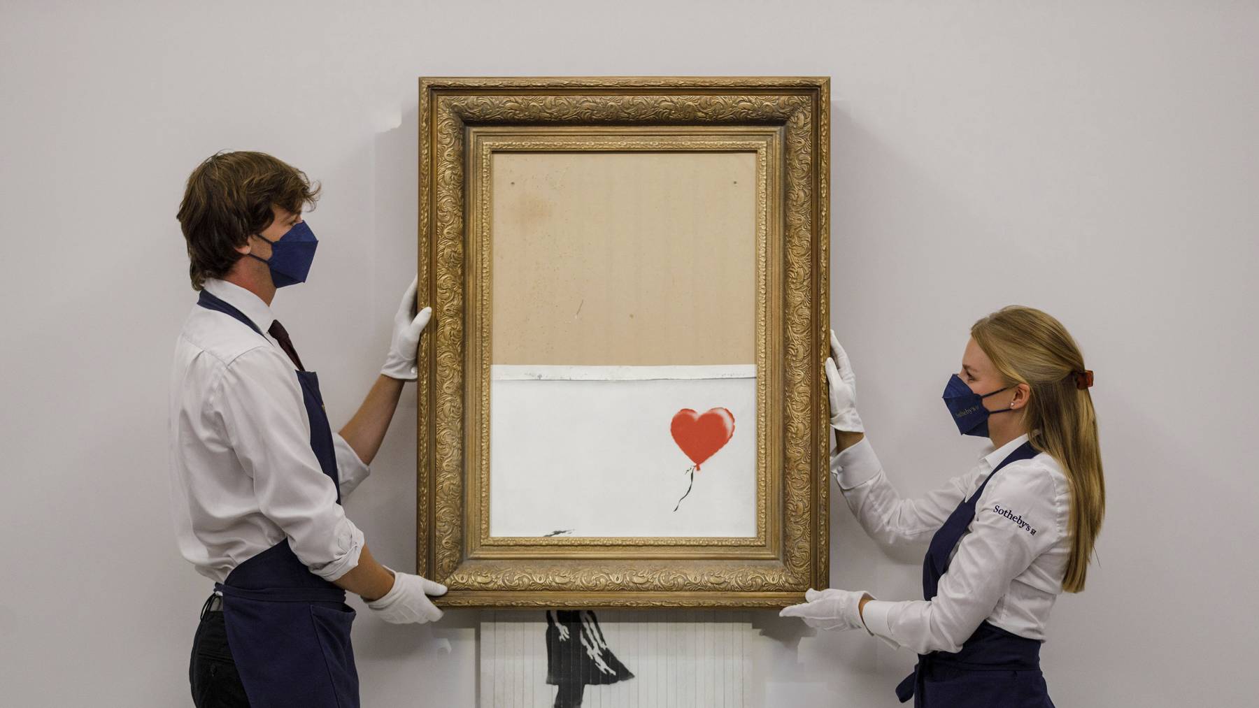 In this handout photo provided by Sotheby's Auction House, the auction for Banksy's «Love is the Bin» takes place in London, Thursday, Oct. 14, 2021. A work by British street artist Banksy that sensationally self-shredded just after it sold for $1.4 million has sold again for $25.4 million at an auction on Thursday. âÄ&#x153;Love is in the BinâÄ was offered by SothebyâÄ&#x2122;s in London, with a presale estimate of $5.5 million to $8.2 million.