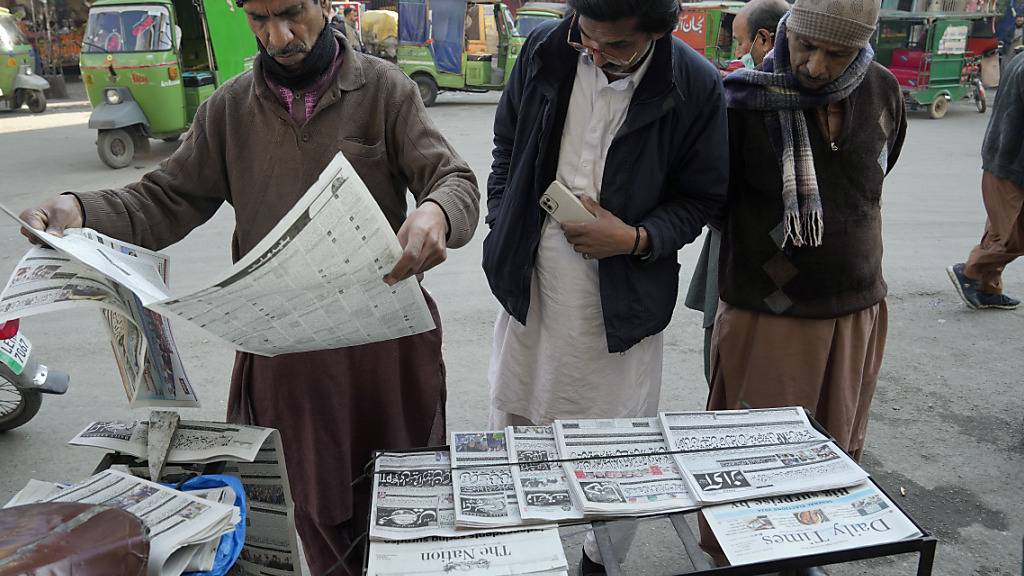 Menschen lesen an einem Stand in Lahore die Morgenzeitung. Foto: K.M. Chaudary/AP/dpa