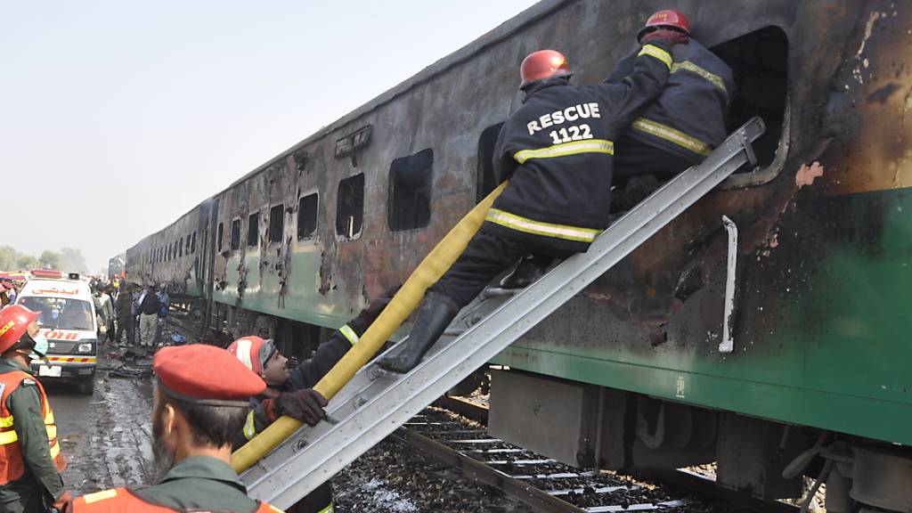 Rettungskräfte suchen nach Überlebenden des Brandes im Zug.