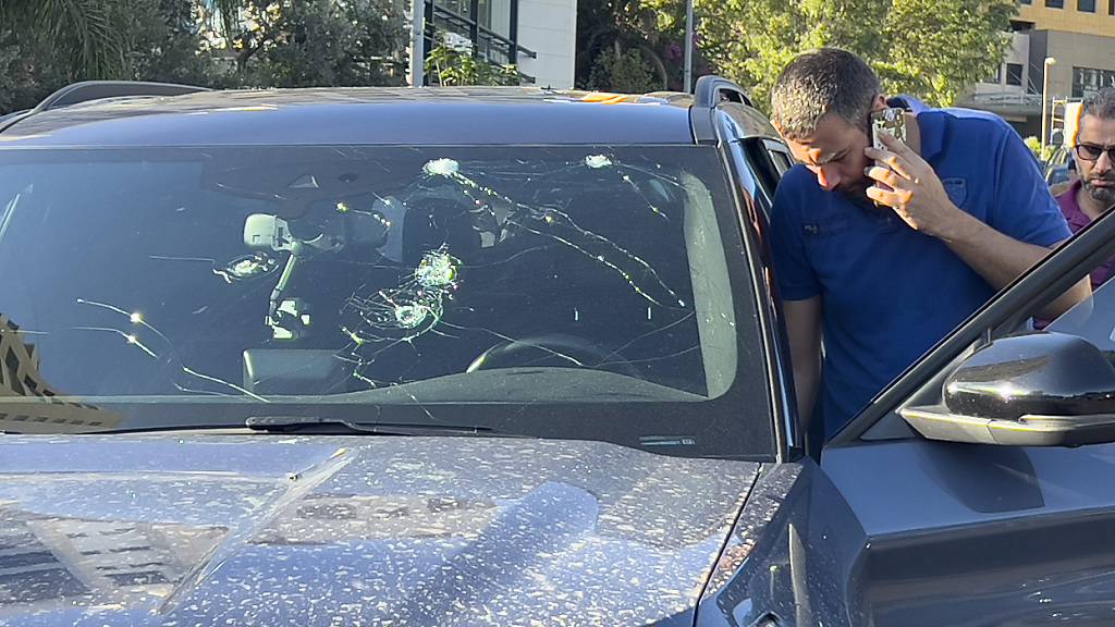 Polizeibeamte untersuchen ein Auto, in dem ein tragbarer Pager explodiert ist. Foto: Hussein Malla/AP/dpa