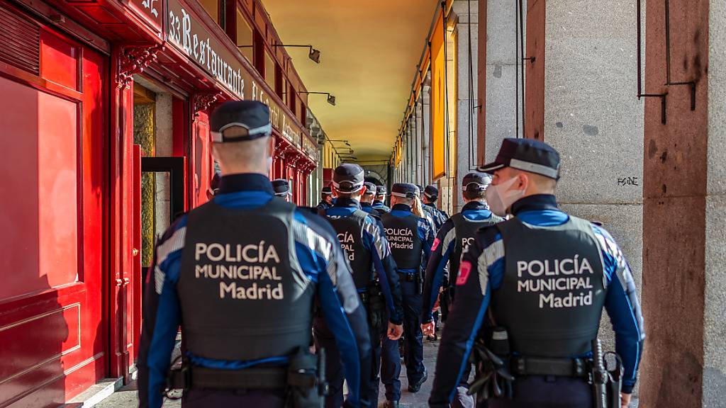 Eine Gruppe Polizisten mit Masken ist in der Stadmitte im Einsatz. Zur weiteren Eindämmung der Corona-Pandemie riegelt sich Madrid zwischen dem 4. und dem 13. Dezember ab. Foto: Diego Radamã©s/Zuma Press/dpa