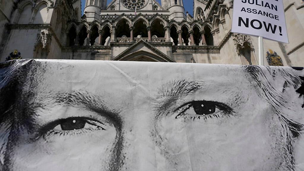 ARCHIV - Ein Poster von Julian Assange wird von Demonstranten vor dem High Court abgestellt. Ein britisches Gericht hat entschieden, dass der WikiLeaks-Gründer Assange Berufung gegen die Anordnung seiner Auslieferung an die USA wegen Spionagevorwürfen einlegen kann. Foto: Kin Cheung/AP/dpa