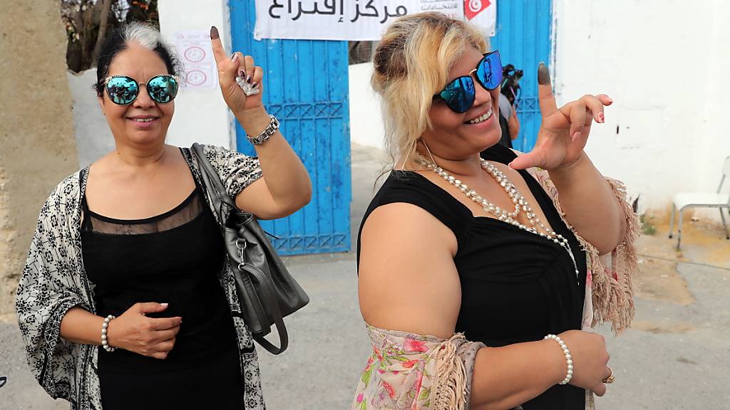 Zwei Frauen vor einem Wahllokal in Tunis mit tintengefärbtem Zeigefinger - der Beleg, dass sie an den Präsidentenwahlen teilnahmen.