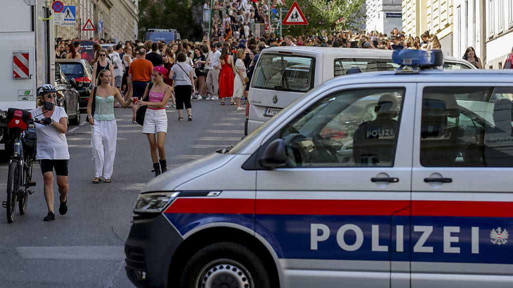 Ein Polizeiauto in der Nähe von versammelten «Swifties». Foto: Heinz-Peter Bader/AP/dpa