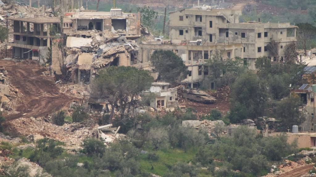Israelische Soldaten fahren einen Panzer in ein Dorf im Südlibanon, gesehen vom Norden Israels aus. Foto: Ariel Schalit/AP/dpa