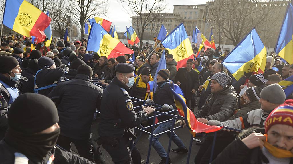 Polizisten ringen in Bukarest mit Demonstranten, die gegen geplante Corona-Maßnahmen demonstrieren. Foto: Alexandru Dobre/AP/dpa