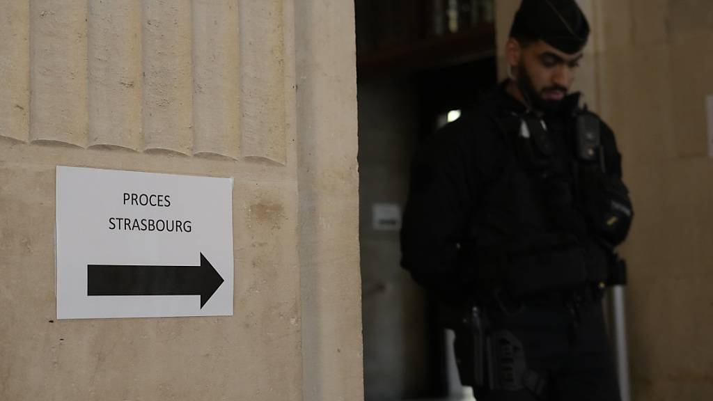 ARCHIV - Ein Polizist steht Wache am Eingang des Pariser Gerichtsgebäudes beim Prozess um den Terroranschlag auf den Straßburger Weihnachtsmarkt. Im Prozess um den Terroranschlag beim Straßburger Weihnachtsmarkt hat ein Schwurgericht einen Helfer des Täters zu 30 Jahren Haft verurteilt. Mit der Beschaffung von Waffen habe der 42-jährige Hauptangeklagte dem Täter bei der Umsetzung seiner Terrorpläne geholfen, urteilte das Gericht in Paris am Donnerstagabend. Foto: Thibault Camus/AP/dpa