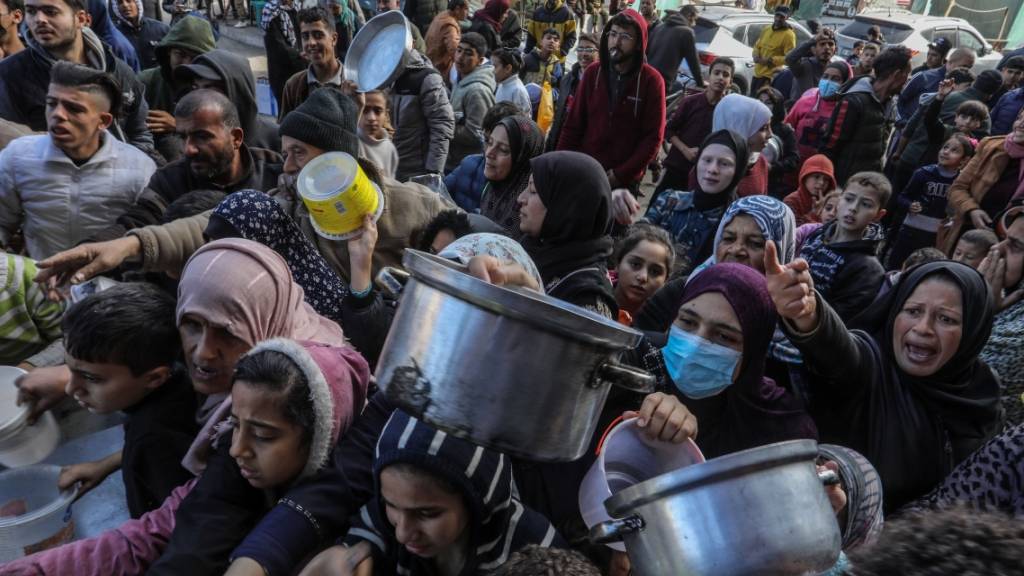 Vertriebene Palästinenser warten in Rafah, im Süden des Gazastreifens, auf Lebensmittel, die von palästinensischen Freiwilligen verteilt werden. Foto: Abed Rahim Khatib/dpa