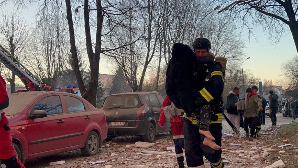HANDOUT - Ein Retter evakuiert ein Kind nach einem russischen Angriff (Archivbild). Foto: Uncredited/Ukrainian Emergency Service/AP/dpa - ACHTUNG: Nur zur redaktionellen Verwendung und nur mit vollständiger Nennung des vorstehenden Credits
