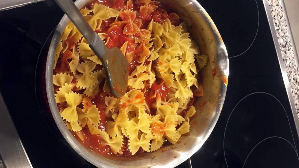 Die Tester Pasta in der Tomatensauce kochen