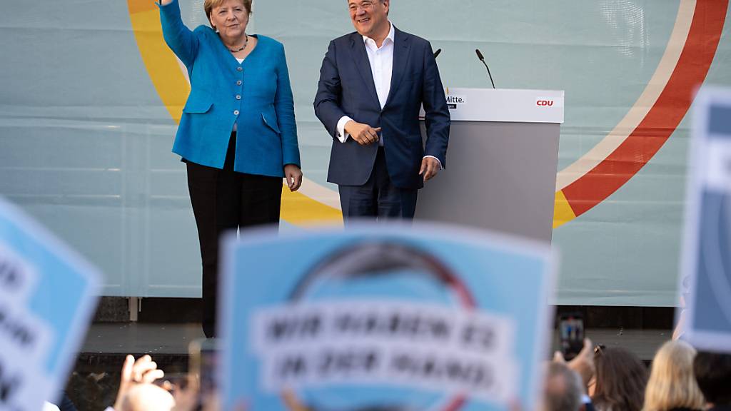Bundeskanzlerin Angela Merkel und Armin Laschet, Ministerpräsident von Nordrhein-Westfalen, Bundesvorsitzender der CDU und Spitzenkandidat seiner Partei, stehen bei einem gemeinsamen Wahlkampfauftritt auf der Bühne. Foto: Federico Gambarini/dpa