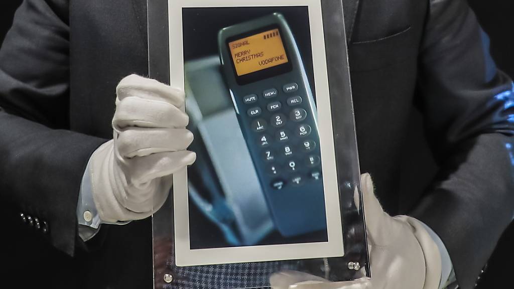 Ein Mitarbeiter des Auktionshauses Aguttes zeigt einen digitalen Bilderrahmen mit dem ersten SMS.
