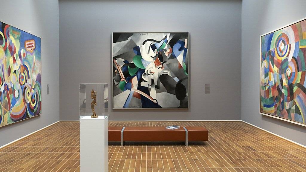 Die Gemälde «Hommage an Blériot» von Robert Delaunay, «Udnie» von Francis Picabia und «Elektrische Prismen» von Sonja Delaunay (von links nach rechts) in der Ausstellung «Kosmos Kubismus. Von Picasso bis Léger» im Kunstmuseum Basel; im Vordergrund der "Tänzer "von Alexander Archipenko.