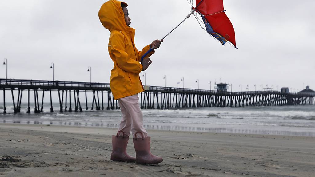 Ein Mädchen kämpft gegen den Wind, während sie am Imperial Beach geht. Foto: K.C. Alfred/The San Diego Union-Tribune/AP/dpa