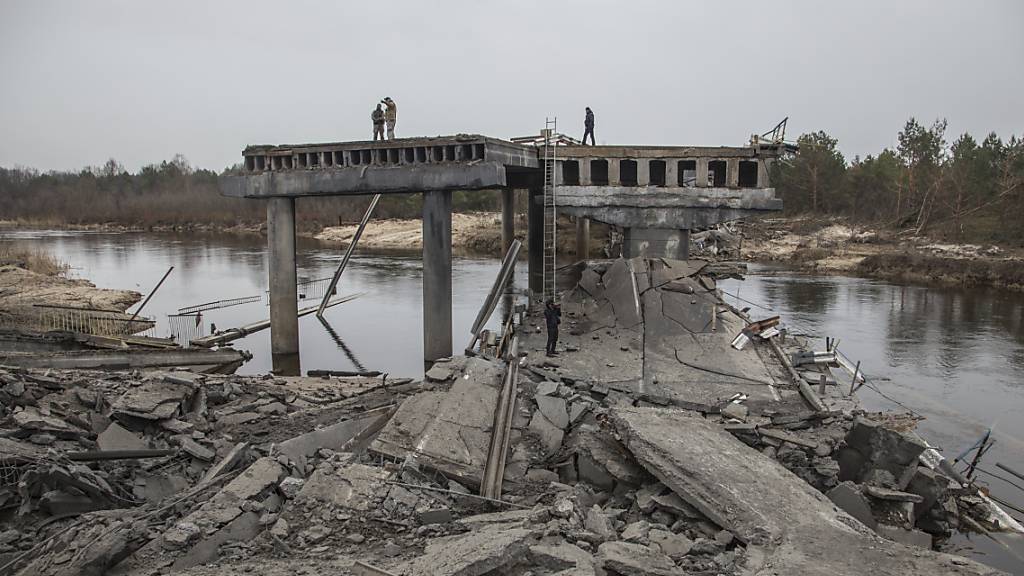 Ukrainische Soldaten stehen auf einer zerstörten Brücke zwischen dem Dorf Dytiatky und Tschernobyl. Foto: Oleksandr Ratushniak/AP/dpa