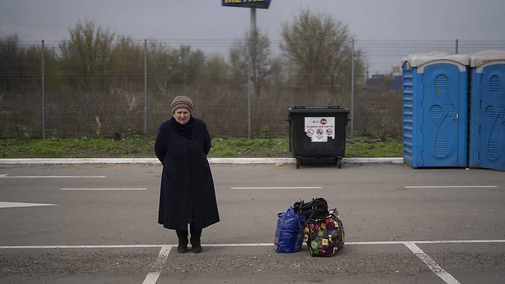 Helena steht neben ihren Habseligkeiten, nachdem sie vor den russischen Angriffen aus Mariupol in ein Flüchtlingszentrum  in Saporischschja geflohen ist. Foto: Leo Correa/AP/dpa