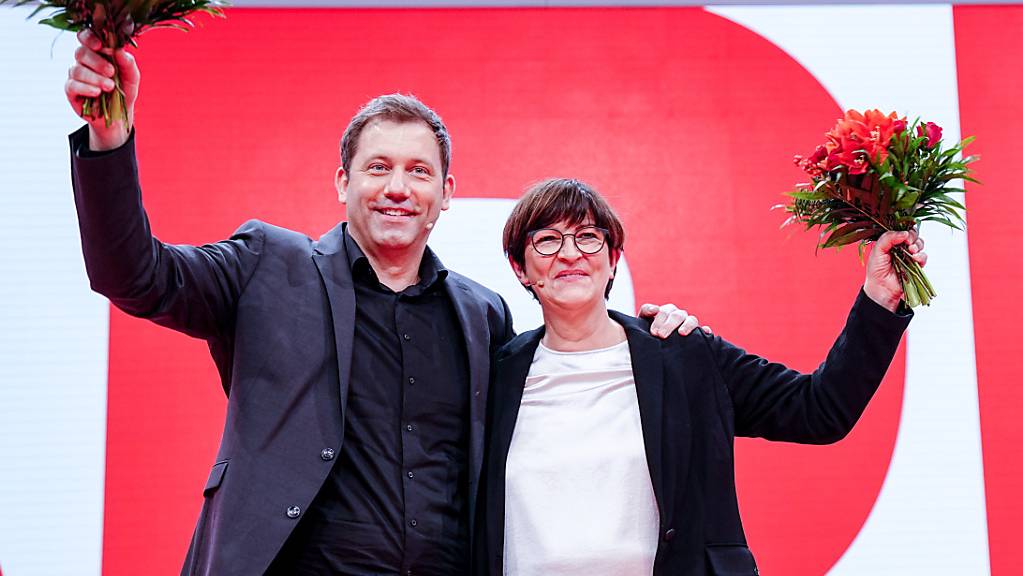 Lars Klingbeil, neugewählter SPD-Parteivorsitzender, und Saskia Esken, neugewählte SPD-Parteivorsitzende, winken mit Blumen beim Bundesparteitag ihrer Partei. Foto: Kay Nietfeld/dpa