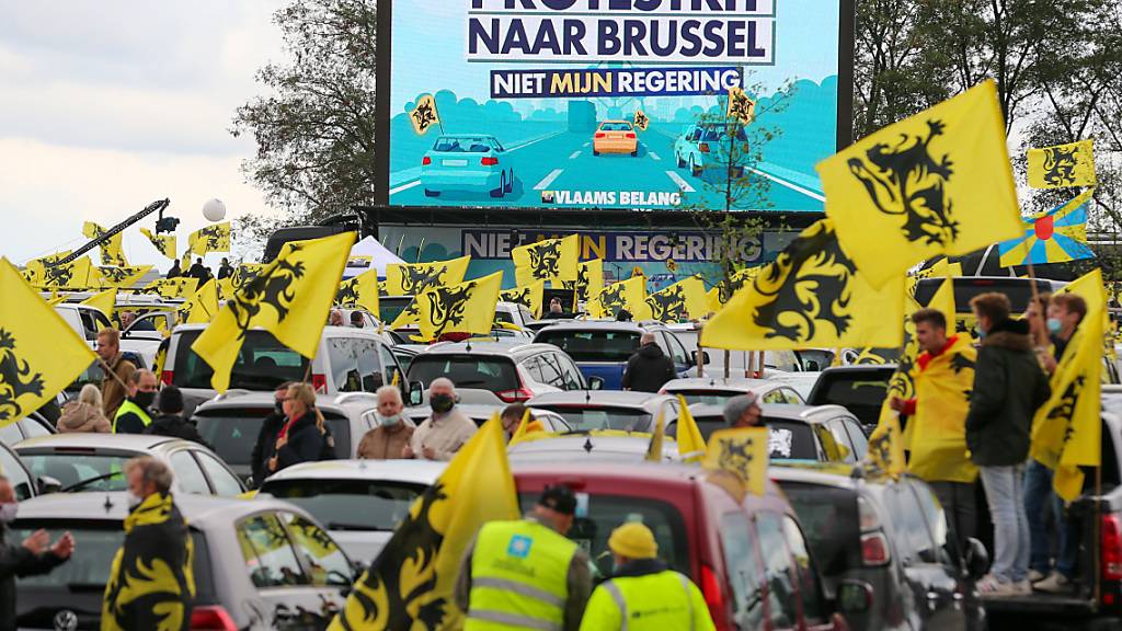 Demonstranten halten zwischen ihren Autos flämische Flaggen während des Protestes der rechtspopulistischen Regionalpartei Vlaams Belang gegen die Regierung. Foto: Nicolas Maeterlinck/BELGA/dpa