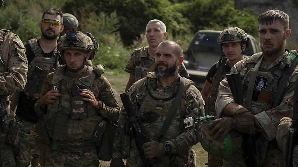 Ukrainische Freiwillige für die Armee hören ihrem Kommandeur nach einer Militärübung zu. Die ukrainische Armee sieht sich an vielen Frontabschnitten im Osten und Süden heftigen Angriffen russischer Truppen ausgesetzt. Foto: Bram Janssen/AP/dpa