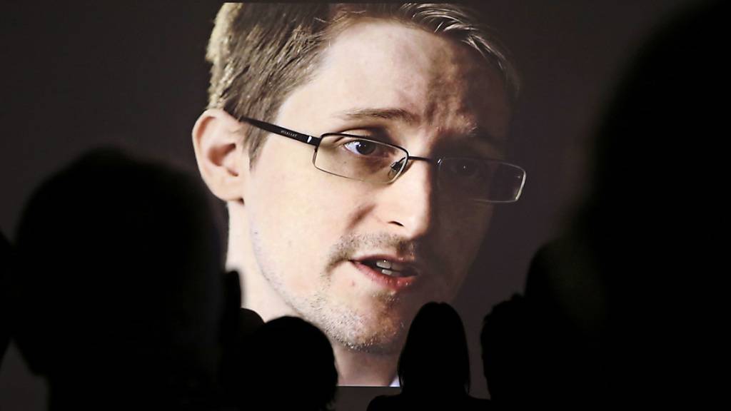 ARCHIV - Edward Snowden ist bei einer Pressevorführung der NDR-Dokumentation «Schlachtfeld Internet - Wenn das Netz zur Waffe wird» auf einer Video-Leinwand zu sehen. Der Whistleblower hat mit der Versteigerung eines digitalen Kunstwerks eine Millionenspende für seine Journalistenstiftung erzielt. Foto: Christian Charisius/dpa
