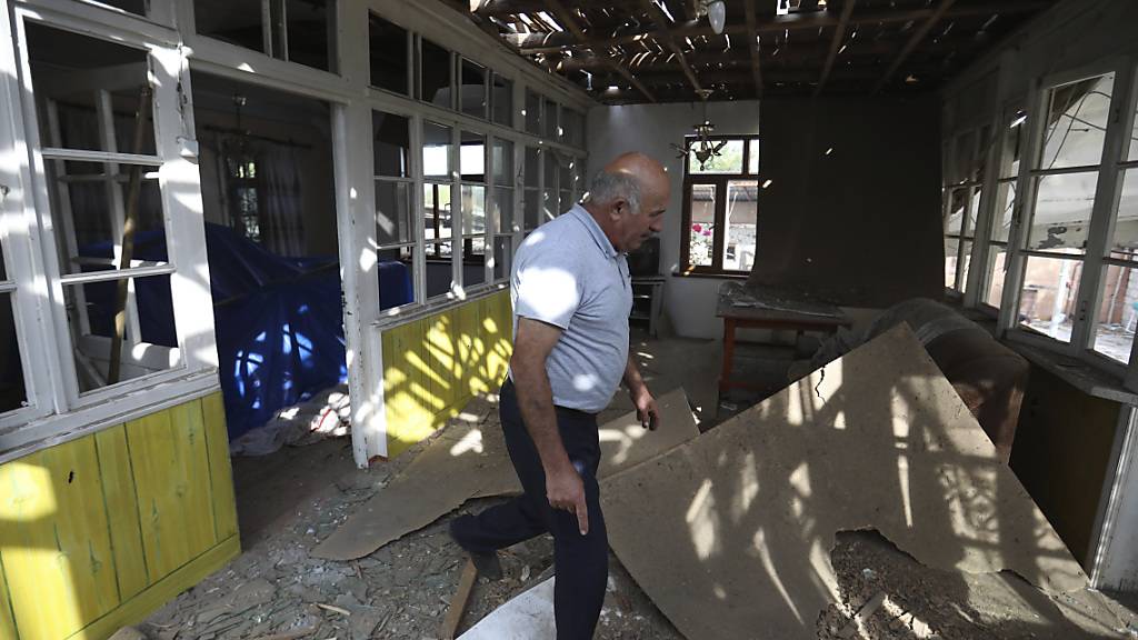 Nach Angriffen armenischer Truppen inspiziert ein Mann sein beschädigtes Haus im aserbaidschanischen Tartar. Foto: Aziz Karimov/AP/dpa