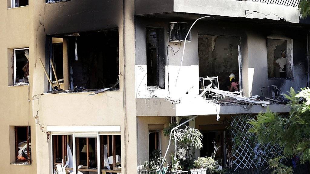 Feuerwehrmänner arbeiten im durch die Explosion zerstörten Wohnhaus.