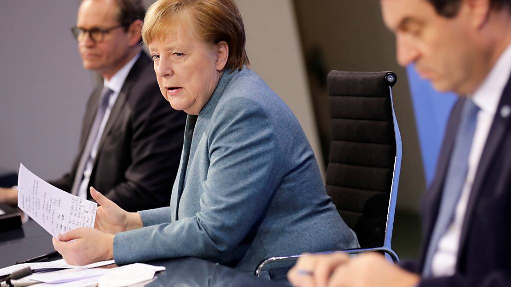 Bundeskanzlerin Angela Merkel äußert sich nach Ende des «Impfgipfels» auf einer Pressekonferenz. Neben ihr der bayerische Ministerpräsident Markus Söder (vorne) und Berlins Regierender Bürgermeister Michael Müller. Foto: Hannibal Hanschke/Reuters-Pool/dpa