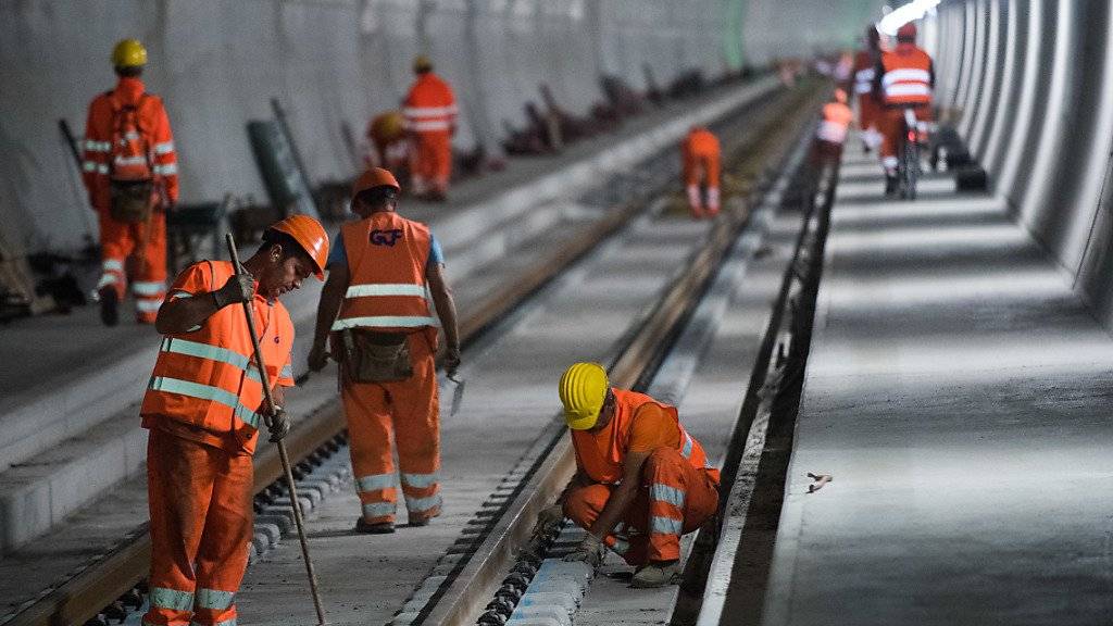 Bauarbeiter verlegen Schienen im Monte Ceneri-Basistunnel zum heutigen Start des Einbaus der Bahntechnik in Camorino. Der 15,4 Kilometer lange Basistunnel zwischen Camorino und Vezia wird im Verlaufe der nächsten Jahre mit den bahntechnischen Installationen ausgerüstet.