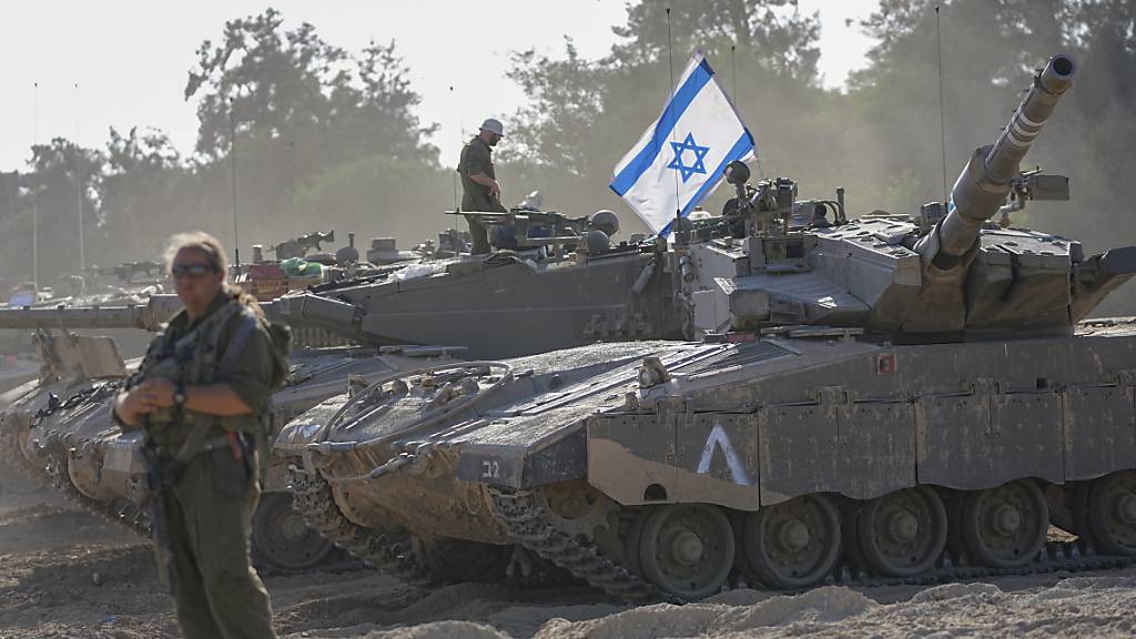 Israelische Soldaten arbeiten an einem Panzer in der Nähe der Grenze zum Gazastreifen im Süden Israels. Das israelische Militär hat seine Bodentruppen in der Nähe des Gazastreifens im Vorfeld einer erwarteten Bodeninvasion verstärkt. Foto: Ohad Zwigenberg/AP/dpa