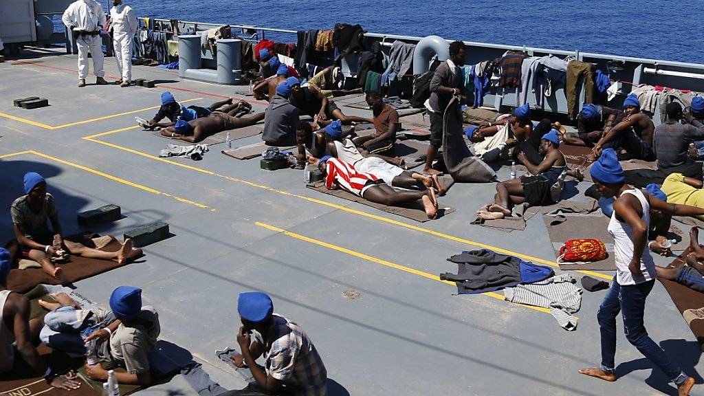 Aufgegriffene Flüchtlinge liegen an Deck eines deutschen Schiffs im Mittelmeer. (Symbolbild)