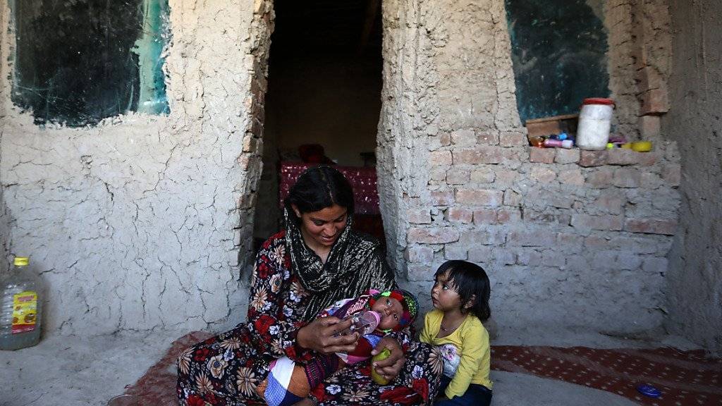 Eine Mutter mit ihren Kindern in einer temporären Unterkunft für Binnenflüchtlinge in Afghanistan.