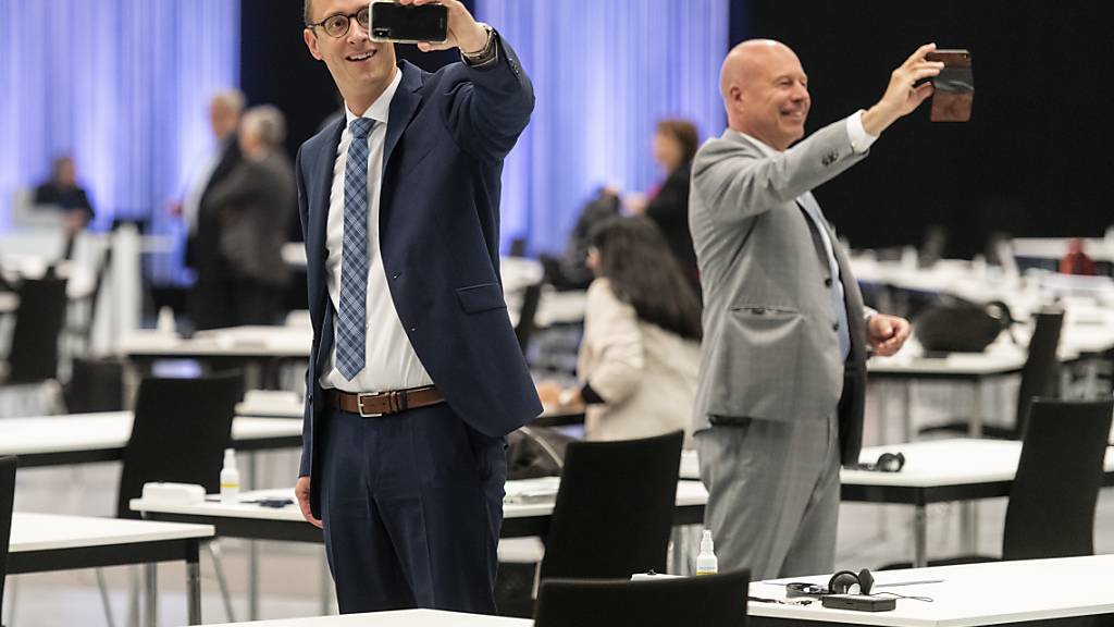 Martin Candinas (CVP/GR), links, und Fabio Regazzi CVP/TI, machen Selfies am ersten Tag der ausserordentlichen Session der Eidgenössischen Räte zur Corona-Krise im Nationalrat in einer Ausstellungshalle der Bernexpo in Bern.