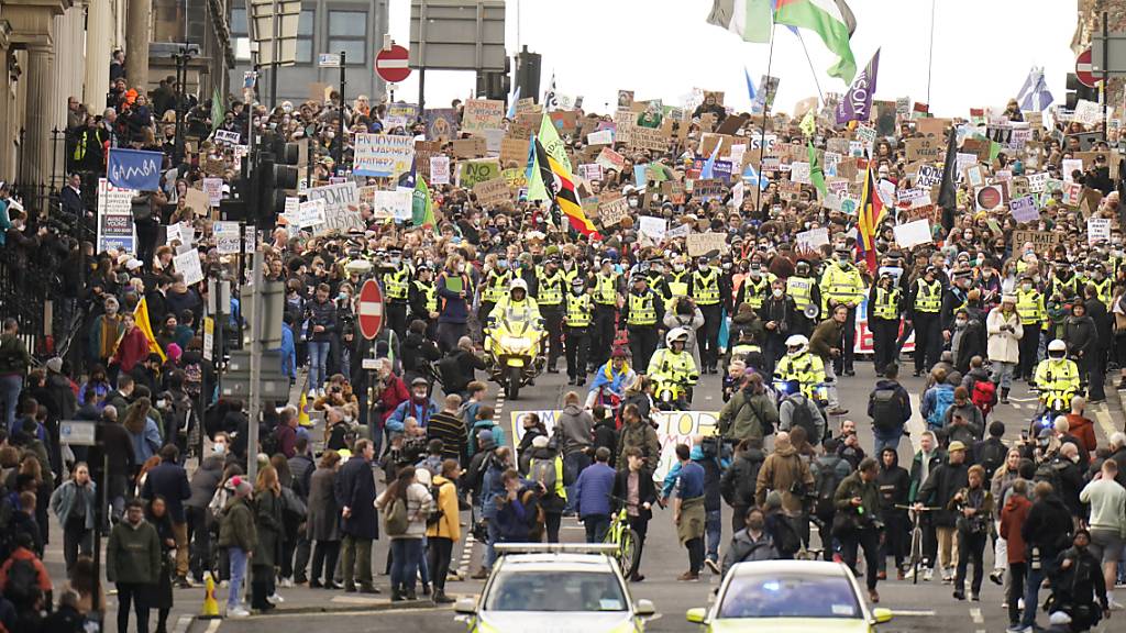 Demonstrierende ziehen mit Bannern durch die Straßen von Glasgow. Foto: Danny Lawson/PA Wire/dpa