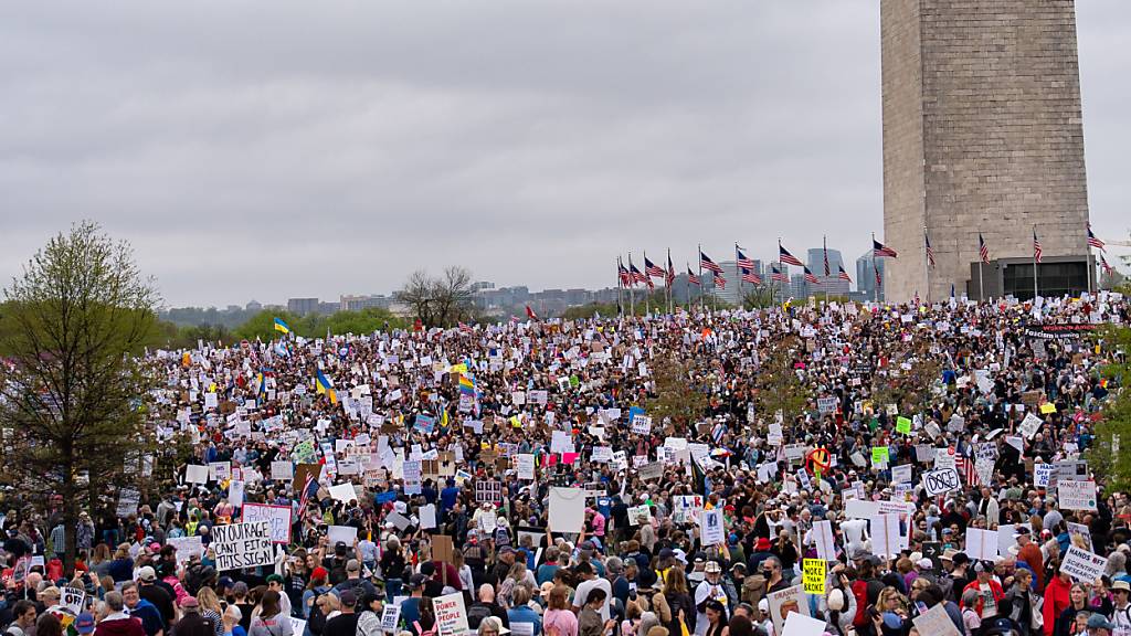 Demonstranten nehmen mit Plakaten am nationalen Aktionstag «Hände weg!» gegen US-Präsident Trump und dem Unternehmer Musk am Washington Monument teil. Foto: Jen Golbeck/SOPA Images via ZUMA Press Wire/dpa