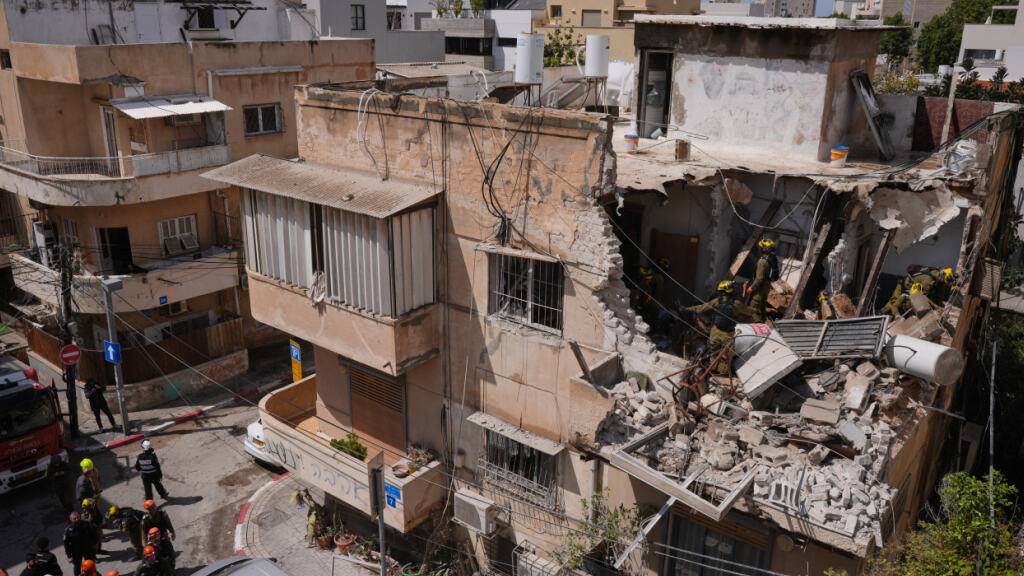 Beamte des israelischen Heimatfrontkommandos inspizieren ein Wohnhaus, das von einer iranischen Rakete getroffen wurde. Foto: Maya Levin/AP/dpa