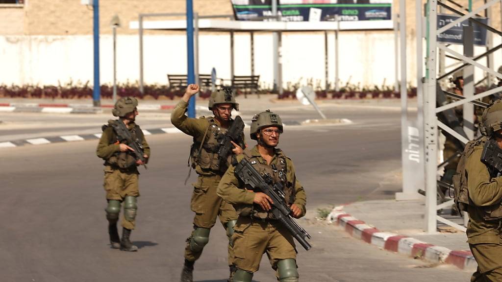 Israelische Soldaten sichern das Gebiet nach den Angriffen der Hamas. Die im Gazastreifen herrschende islamistische Hamas, die von Israel, der EU und den USA als Terrororganisation eingestuft wird, hatte den Beginn einer «Militäroperation» gegen Israel verkündet. Foto: Ilia Yefimovich/dpa