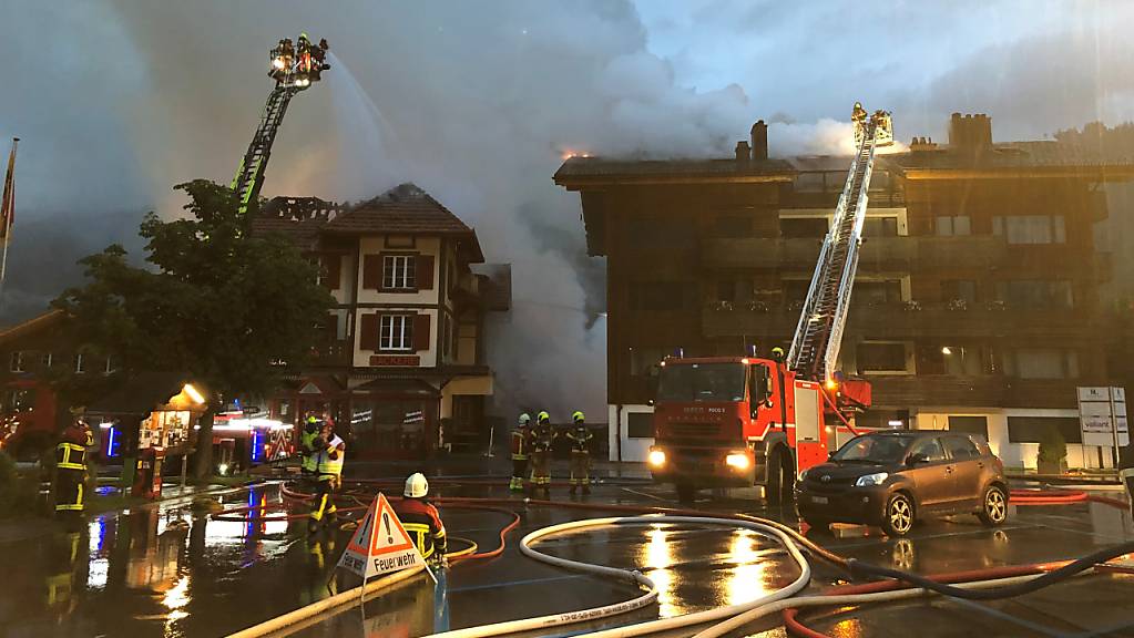 Die Feuerwehr bekämpft von Drehleitern aus die Brände im Wohn- und Geschäftsgebäude und im Mehrfamilienhaus.