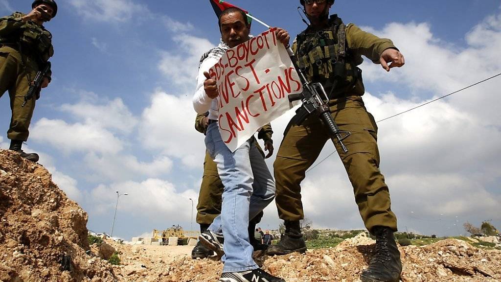 Ein Palästinenser, der sich auf eine bekannte antiisraelische Boykottgruppierung bezieht, wird von israelischen Soldaten zurückgewiesen. (Archivbild)