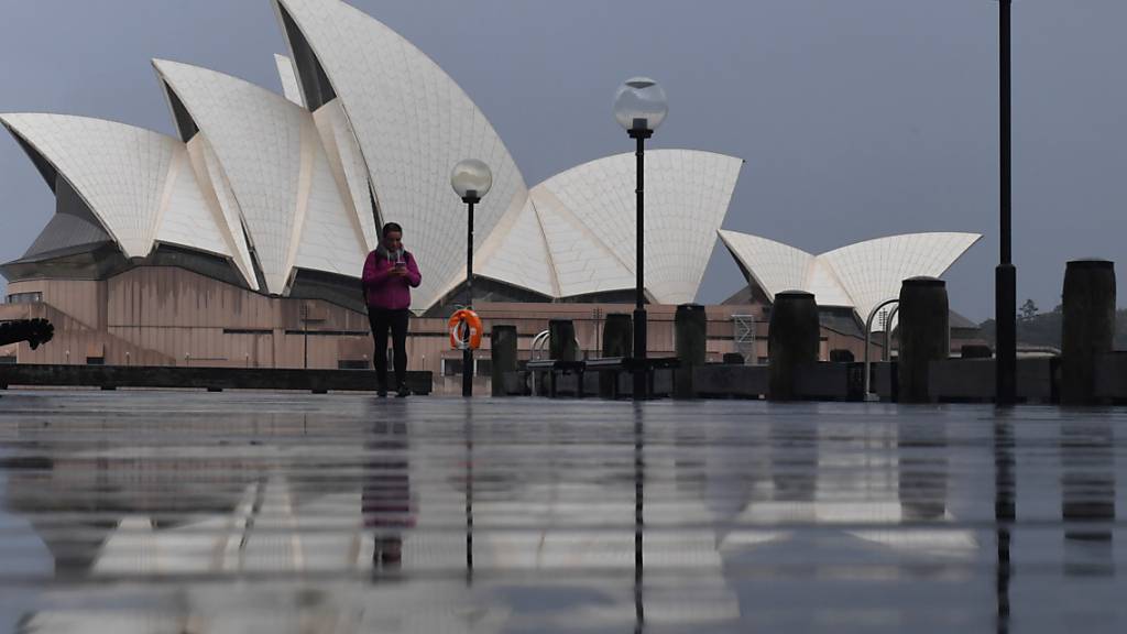 A pedestrian walks past the Sydney Opera House in Sydney, Saturday, July 10, 2021. Tough new restrictions are now in place for Greater Sydney after another spike in COVID-19 cases. (AAP Image/Mick Tsikas) NO ARCHIVING