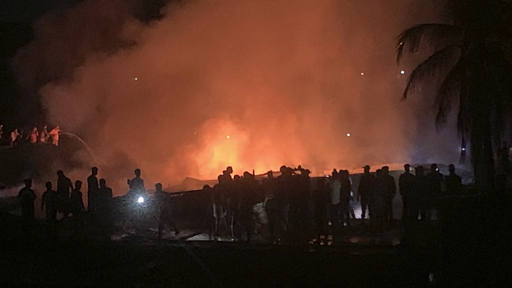 Menschen arbeiten daran, ein Feuer in einem behelfsmäßigen Markt in der Nähe eines Rohingya-Flüchtlingslagers zu löschen. Das Feuer brach am frühen heutigen Freitag aus.
